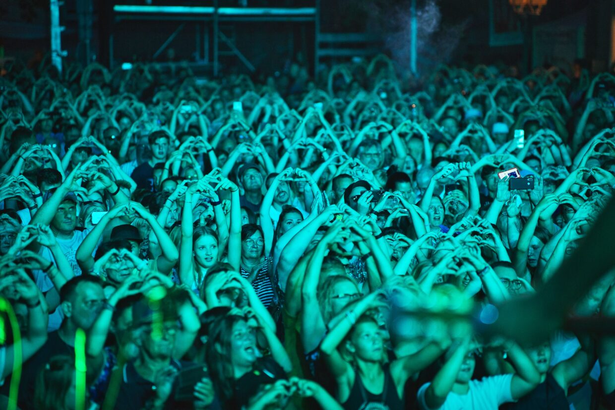Publikum hebt Hände hoch und macht ein Herz